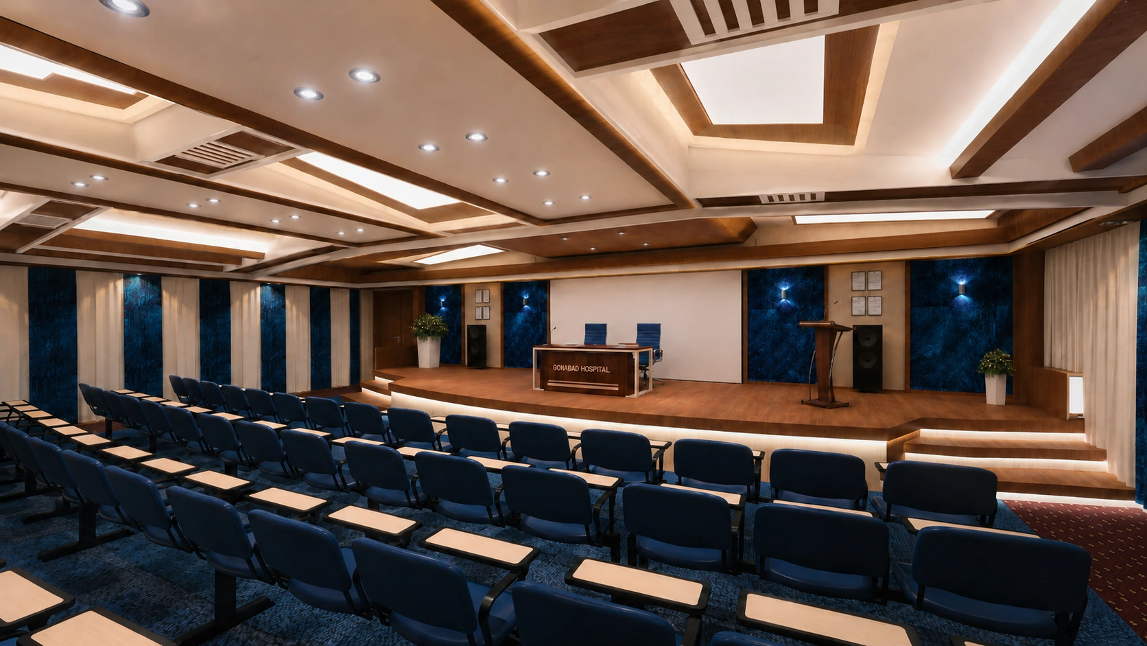 Behloul Gonabadi Hospital auditorium in Gonabad with rows of dark blue seating facing a timber stage and projection screen