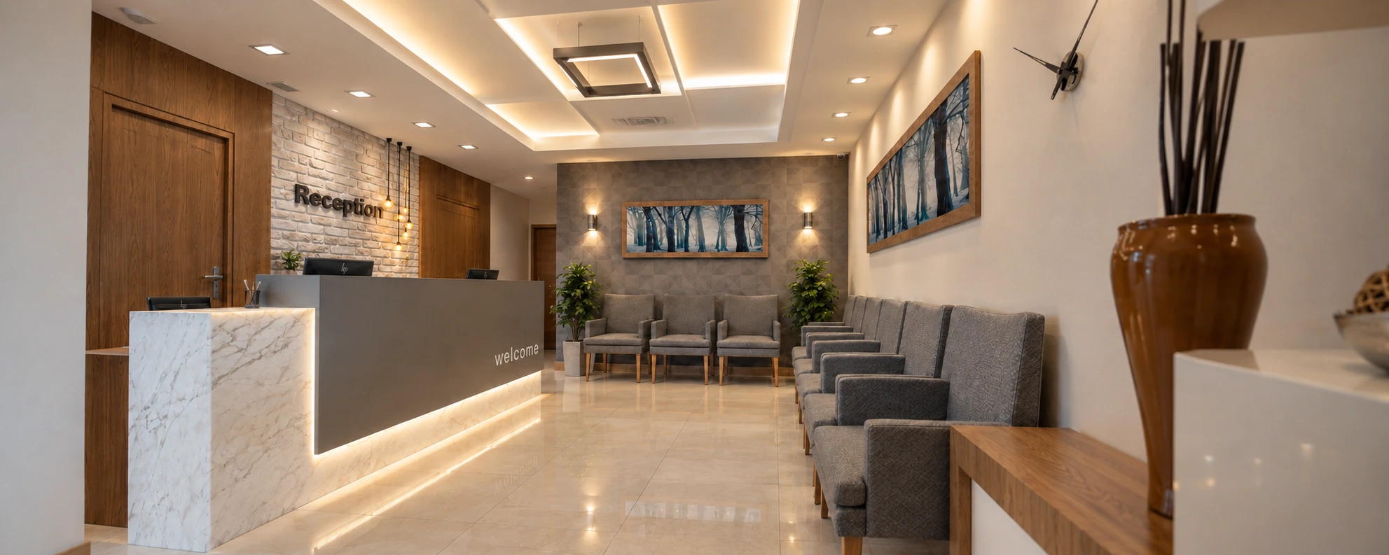 Reception and waiting area with gray seating and layered ceiling lighting at the clinic.