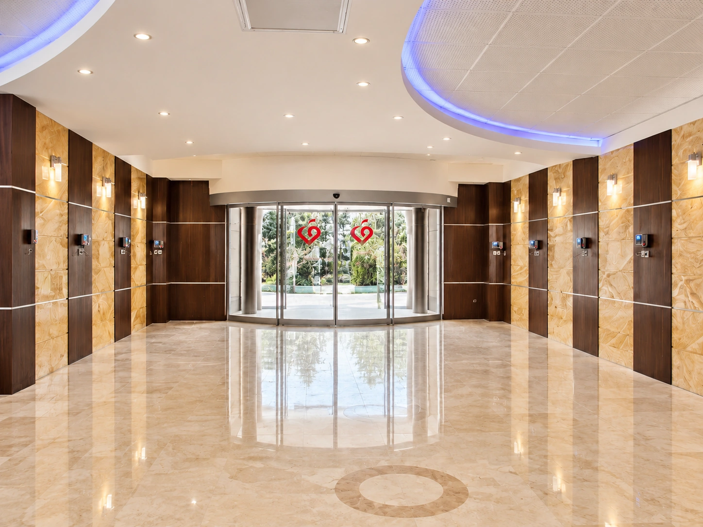 Main lobby entrance at Shahid Rajaee Heart Center with glazed doors, light stone floor and timber-stone wall panels