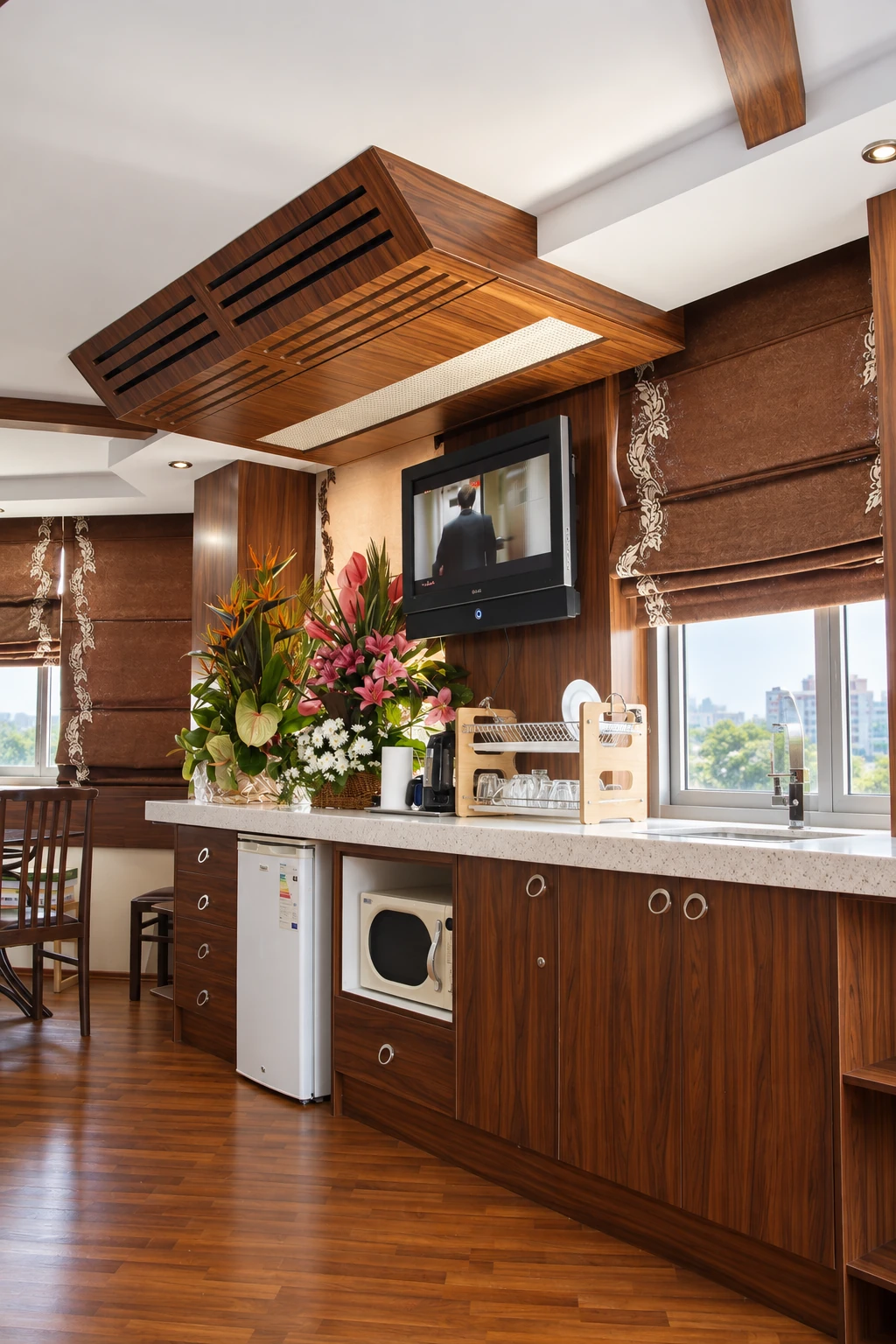 Service kitchenette in the Atiyeh Hospital Ofoq Diplomat room with wood cabinetry, sink, refrigerator and daylight