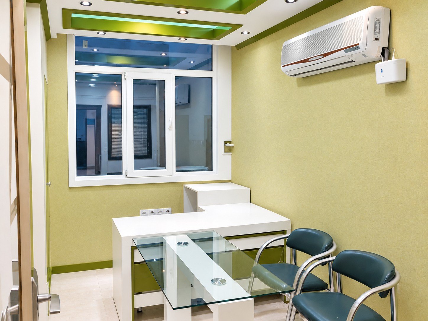 Consultation room interior of Yekta Laboratory with white furniture and green architectural details