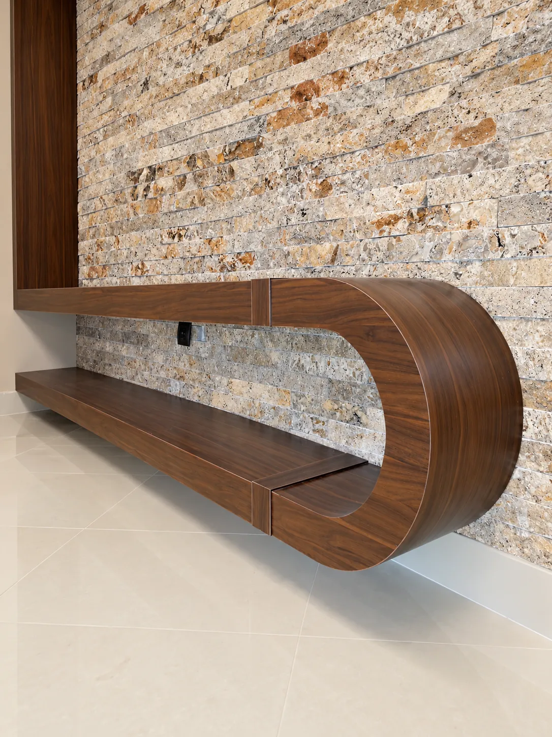 Custom curved walnut wall bench detail against the stone feature wall at Jam Building