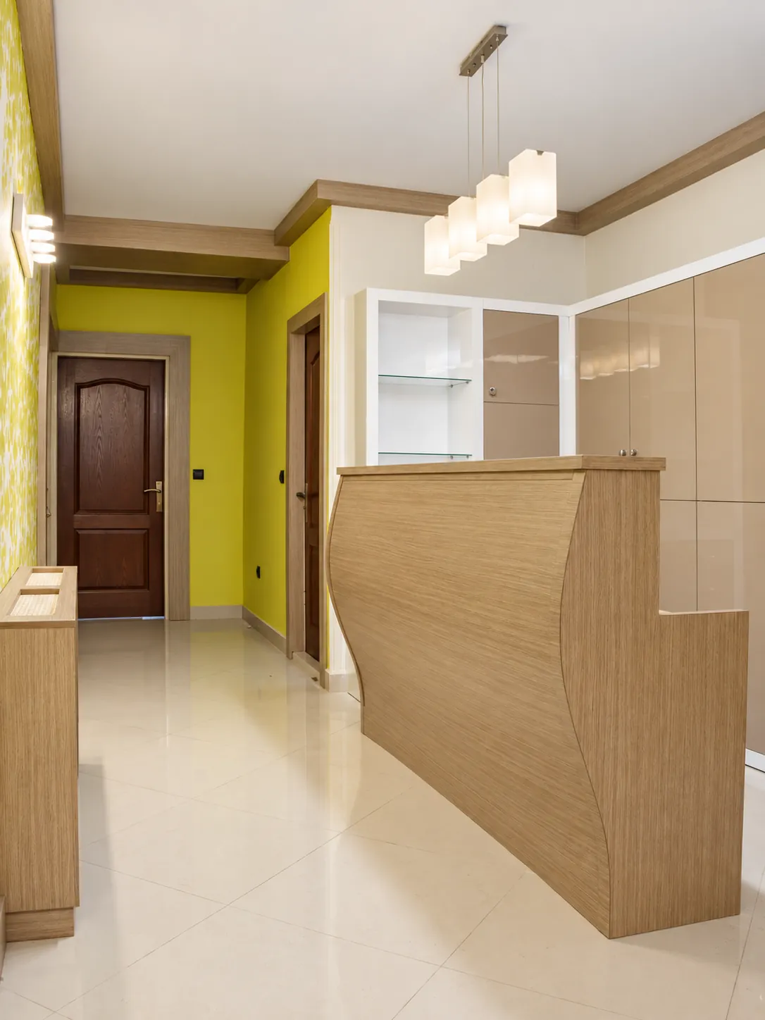 Jam Building reception area with curved light-wood desk, built-in storage and pendant lighting