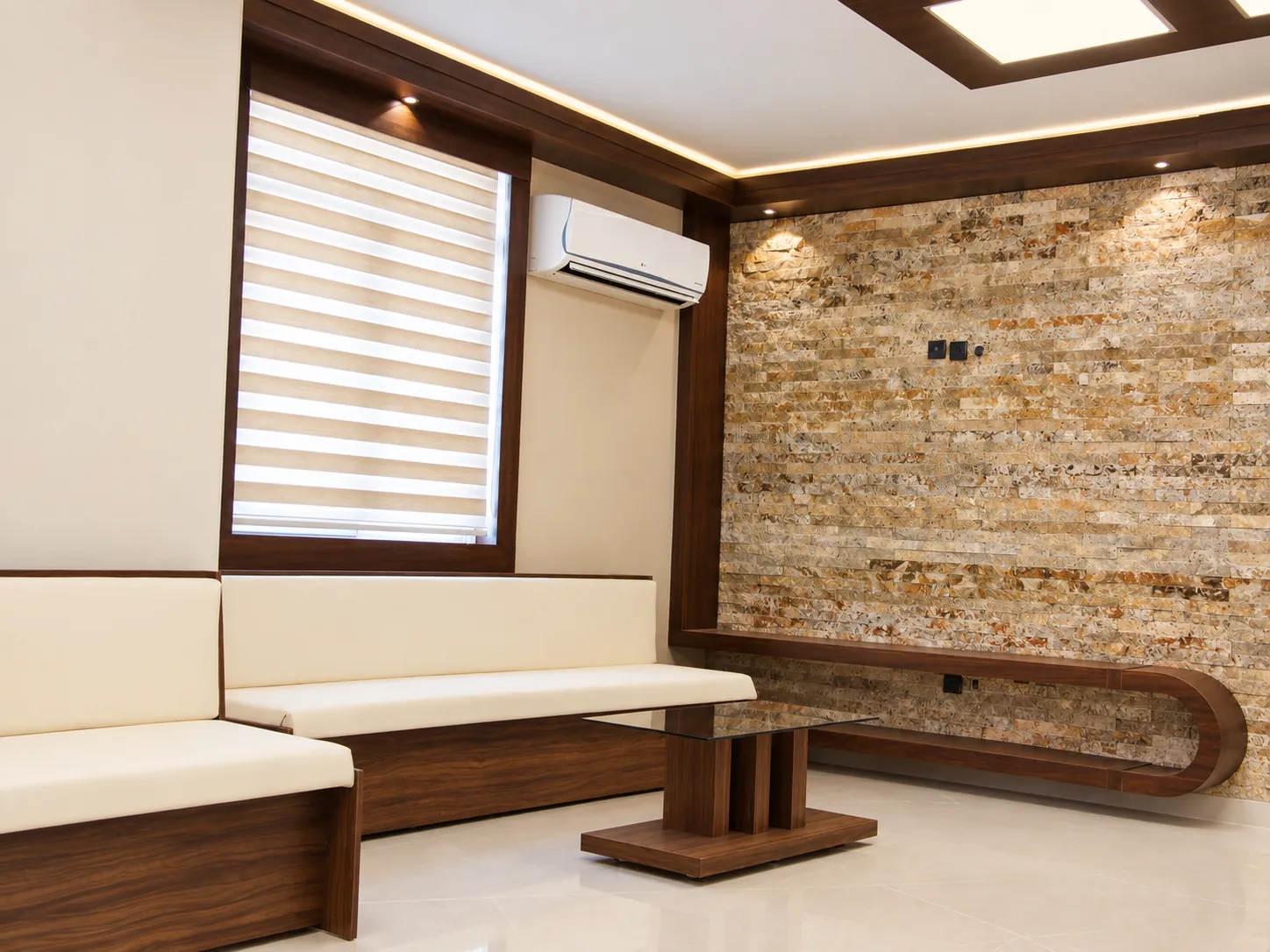 Waiting area at Jam Building with natural stone feature wall, custom wood bench and cream seating